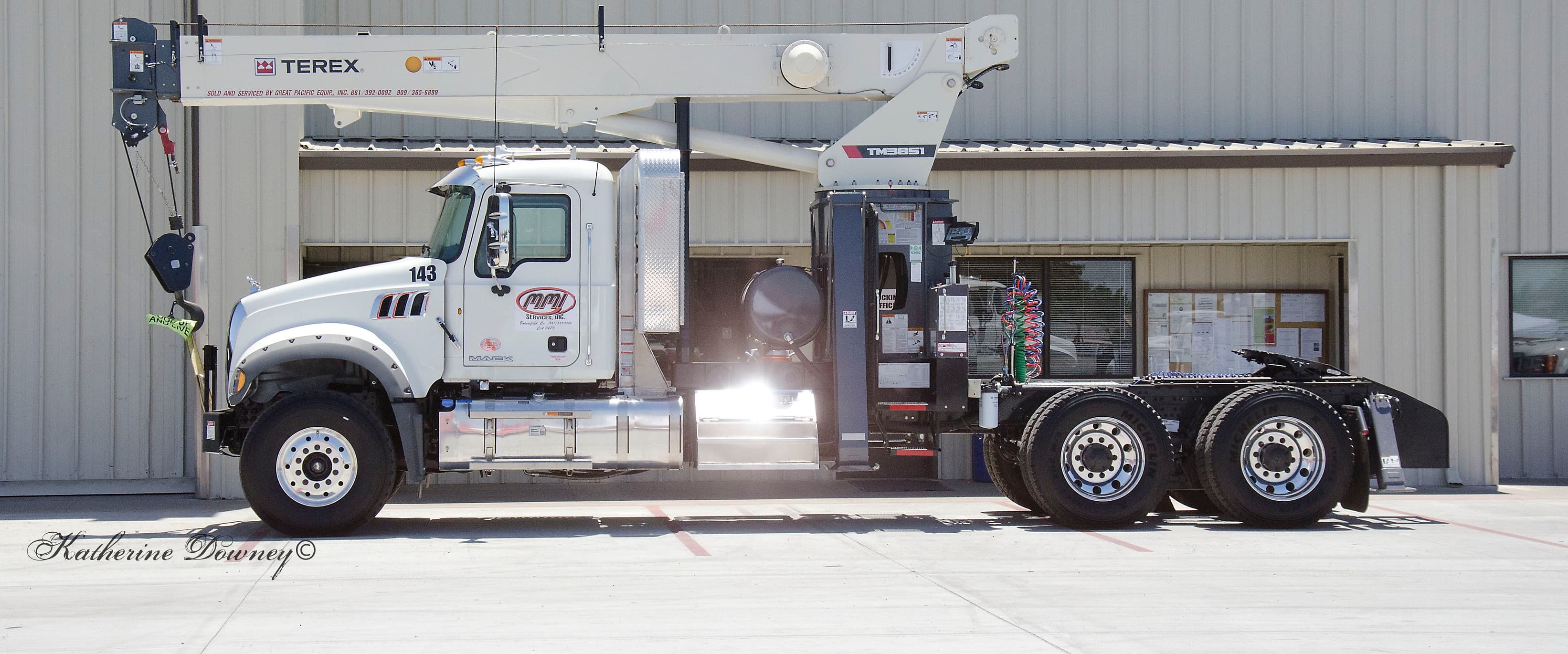 MMI crane and winch truck setting heavy iron on a Kern County location